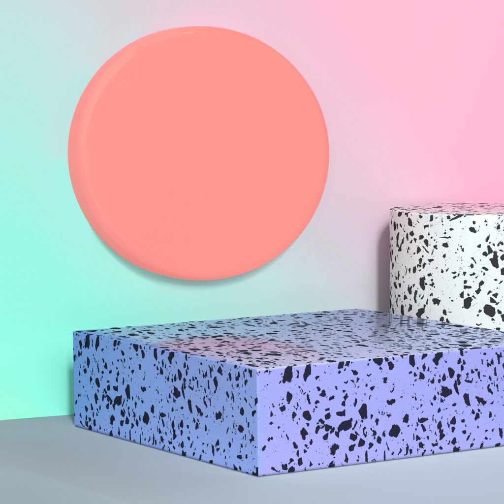 A pastel-colored abstract scene with a peach circle floating against a gradient background of teal and pink. Below, two terrazzo-style blocks, one white with black specks and one purple with black specks, are stacked.
