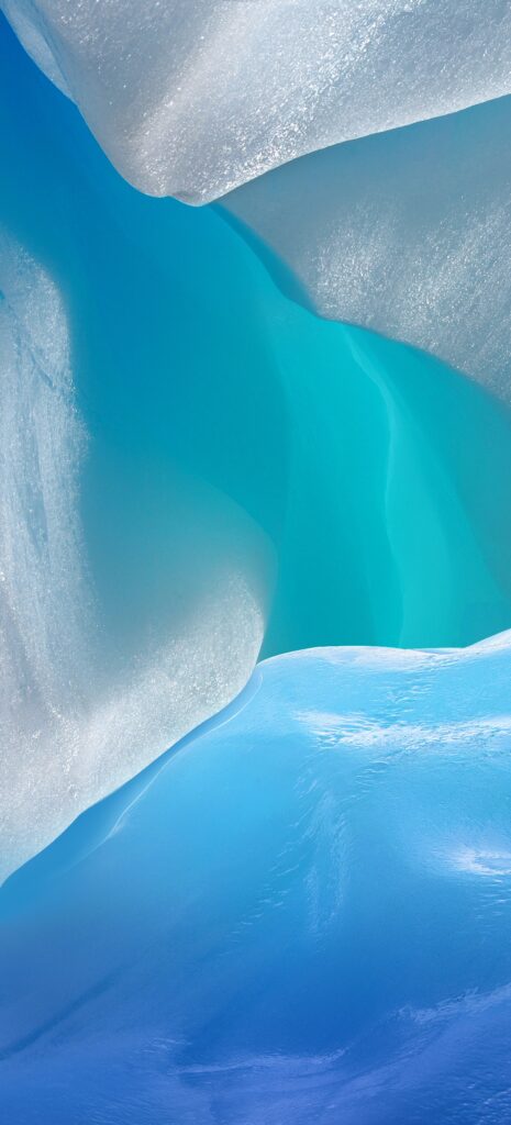 A close-up of an abstract ice formation featuring smooth, flowing curves in shades of blue and white. The textures suggest a serene and cool ambiance, highlighting the natural beauty of ice.
